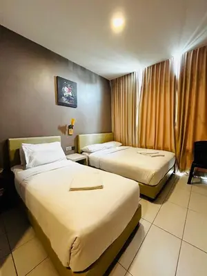 a hotel room with two beds and a window at DS Hotel in Ipoh