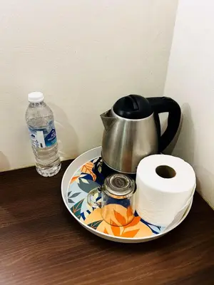 a plate with a tea pot and a roll of toilet paper at DS Hotel in Ipoh