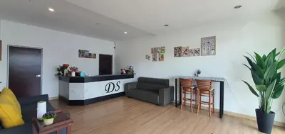 a living room with a bar with a couch and a chair at DS Hotel in Ipoh