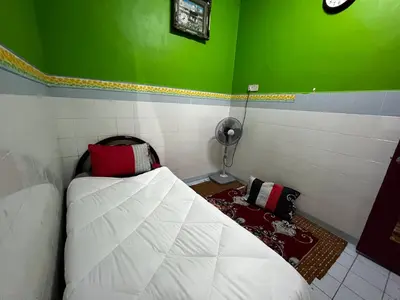 a small room with a bed and a fan at Wan Homestay Kulim Hi-Tech Mslliim only in Kulim