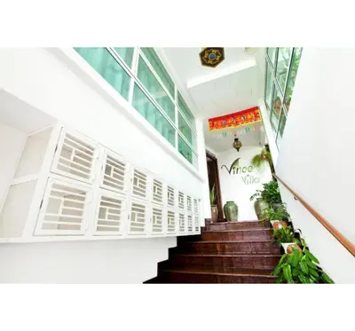 a staircase in a building with white walls and a stair case at Hotel O Vince Villa in Bukit Mertajam
