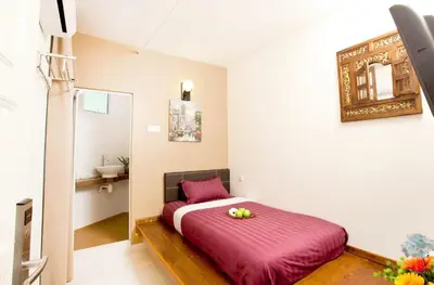 a bedroom with a bed with a sink and a mirror at Hotel O Vince Villa in Bukit Mertajam