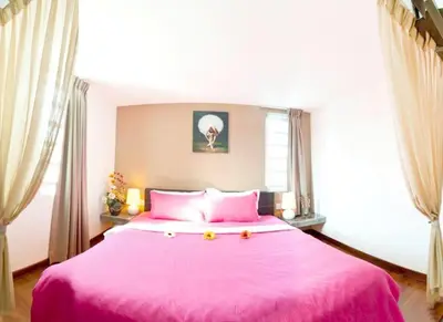 a bedroom with a large pink bed with pink sheets at Hotel O Vince Villa in Bukit Mertajam