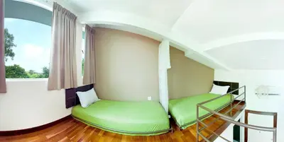 a room with two green beds and a window at Hotel O Vince Villa in Bukit Mertajam