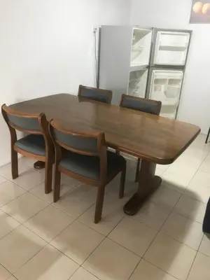 a wooden table with four chairs around it at Batu Kawan HS in Simpang Ampat
