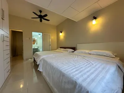 a bedroom with two beds and a ceiling fan at Little England B9 in Bukit Fraser