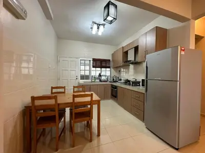 a kitchen with a wooden table and a refrigerator at Little England B9 in Bukit Fraser