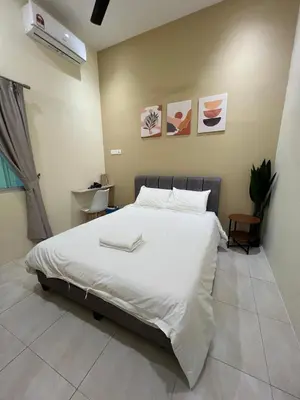 a bedroom with a large bed with white sheets at The Five Cottage @ Botani Ipoh in Ipoh
