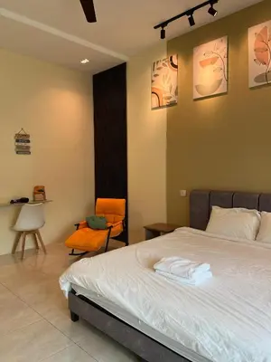 a bedroom with a bed with two towels on it at The Five Cottage @ Botani Ipoh in Ipoh