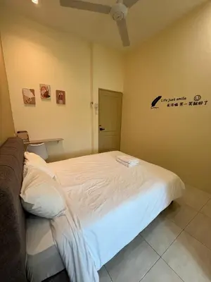 a bedroom with a white bed in a room at The Five Cottage @ Botani Ipoh in Ipoh