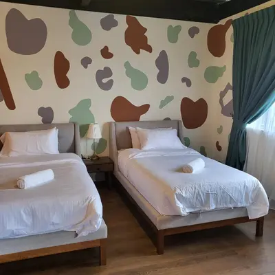 two beds in a room with hearts on the wall at kMah@SomerMansion in Tanah Rata