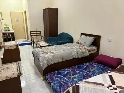 a bedroom with two beds and a chair at Sofea Inn Bukit Merah - Laketown A6116 in Simpang Ampat Semanggol