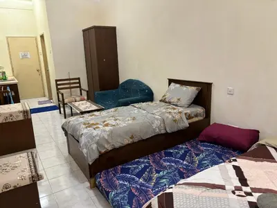 a bedroom with two beds and a chair at Sofea Inn Bukit Merah - Laketown A6116 in Simpang Ampat Semanggol