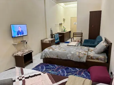 a room with two beds and a flat screen tv at Sofea Inn Bukit Merah - Laketown A6116 in Simpang Ampat Semanggol