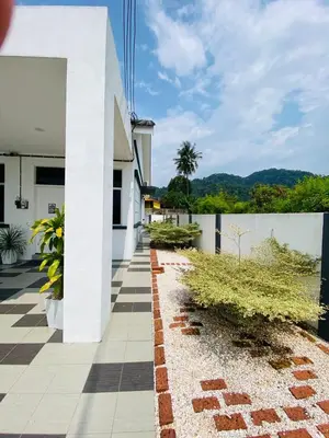 a white building with a brick walkway next to a fence at Mountain View Umoh50 Ipoh End-Lot Wi-fi Cozy in Ipoh