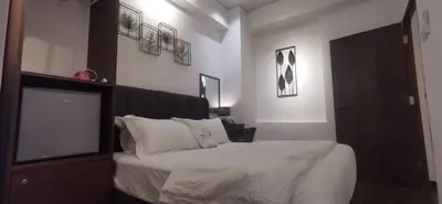 a bedroom with a bed with white sheets and pillows at TREASURE HUNTER At Heritage Georgetown in George Town