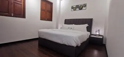 a bedroom with a large bed with white sheets at TREASURE HUNTER At Heritage Georgetown in George Town