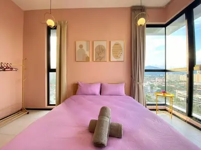 a bedroom with a large pink bed with a large window at Jovial Modern&Stylish `UrbanSuites in Jelutong