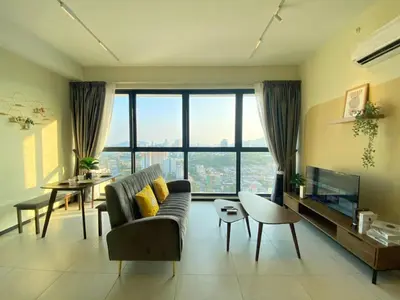 a living room with a couch and a large window at Jovial Modern&Stylish `UrbanSuites in Jelutong