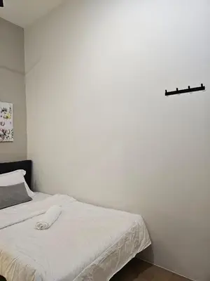 a white bed in a room with a white wall at Summer Home 15 Georgetown Adventist in George Town