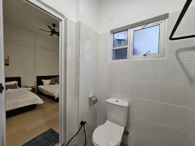 a bathroom with a toilet and a window and a bed at Summer Home 15 Georgetown Adventist in George Town