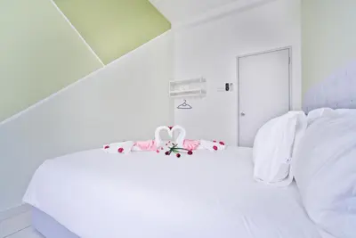 a white bedroom with a white bed with white pillows at The Horizon Ipoh L15 by Grab A Stay in Ipoh
