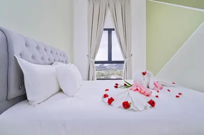 a white bed with flowers on it with a window at The Horizon Ipoh L15 by Grab A Stay in Ipoh