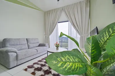 a living room with a couch and a plant at The Horizon Ipoh L15 by Grab A Stay in Ipoh