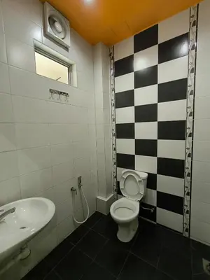 a bathroom with a black and white checkered wall at Hotel O Rumah Rehat Awana in Kampong Nanas