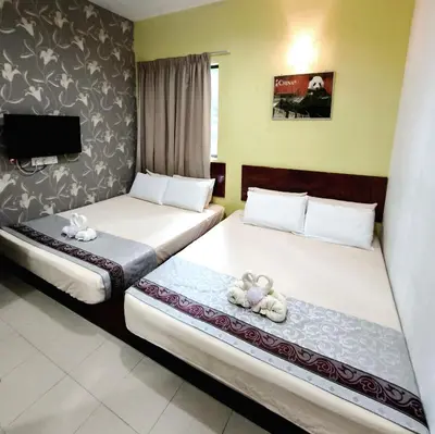 two beds in a hotel room with teddy bears on them at Hotel O Rumah Rehat Awana in Kampong Nanas