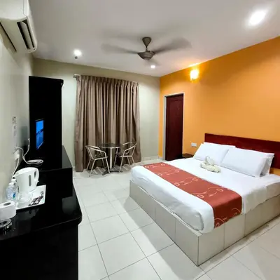 a bedroom with a large bed and a television at Hotel O Rumah Rehat Awana in Kampong Nanas