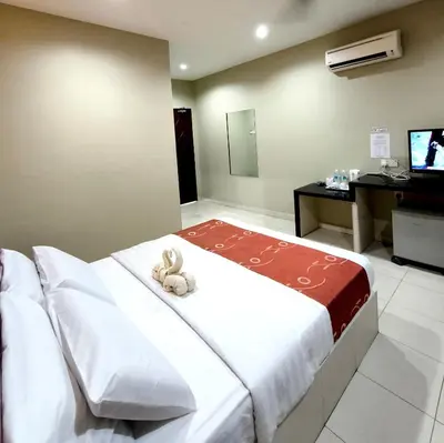 a bedroom with a bed with a teddy bear on it at Hotel O Rumah Rehat Awana in Kampong Nanas