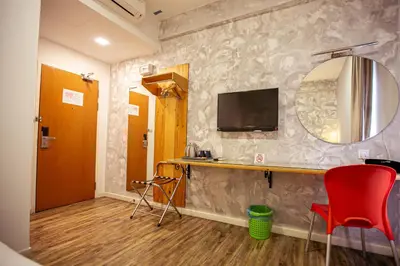 a room with a desk and a television on a wall at Chulia Mansion in George Town