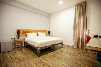 a bedroom with a large bed and a red chair at Chulia Mansion in George Town