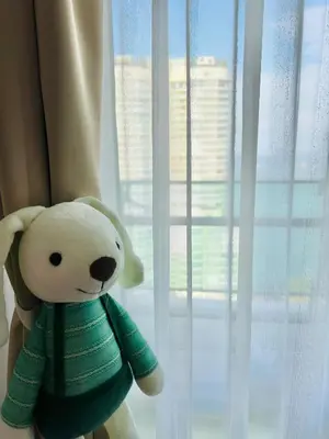 a teddy bear in a green sweater sitting next to a window at Mansion One l 7pax 2R2B l Seaview l Gleneagle l by PerfectSweetHome in George Town