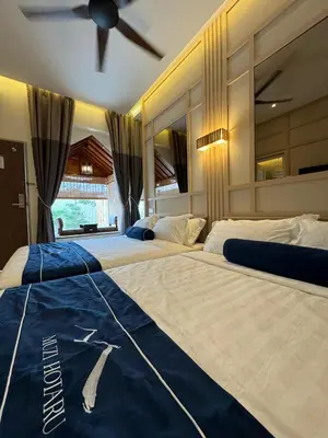 two large beds in a bedroom with a ceiling fan at Muzi Boutique Hotel in Ipoh