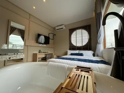 a bathroom with a bath tub and a bed at Muzi Boutique Hotel in Ipoh