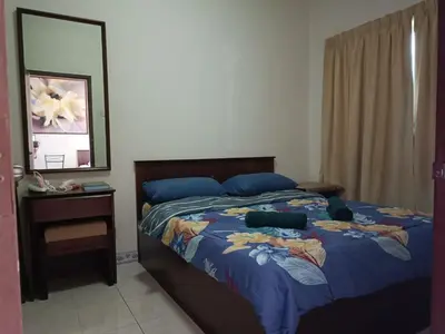 a bedroom with a bed with a blue comforter and a mirror at Sofea Inn Bukit Merah - Suria A7245 in Simpang Ampat Semanggol