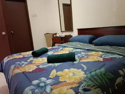 a bedroom with a bed with a floral comforter at Sofea Inn Bukit Merah - Suria A7245 in Simpang Ampat Semanggol