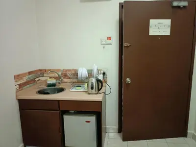 a kitchen with a counter and a sink and a door at Sofea Inn Bukit Merah - Suria A7245 in Simpang Ampat Semanggol