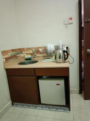 a kitchen with a counter with a sink and a dishwasher at Sofea Inn Bukit Merah - Suria A7245 in Simpang Ampat Semanggol