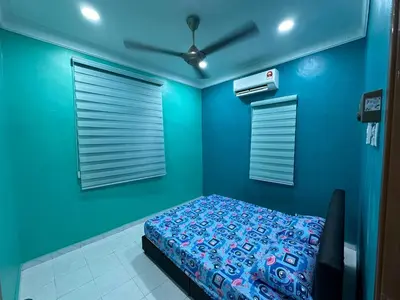 a blue bedroom with a bed and a fan at Shan Homestay in Sungai Petani
