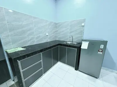 a small kitchen with a sink and a refrigerator at Shan Homestay in Sungai Petani