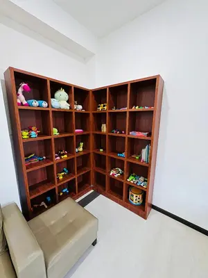 a room with a couch and shelves with toys at Maxwell Merpati Taiping Homestay in Kamunting