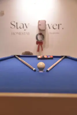 a pool table with two cue sticks and a ball at The Karaoke Homes Ipoh, Oldtown in Ipoh