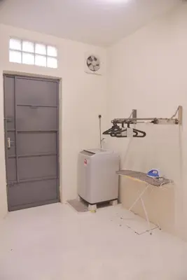 a white room with a door and a chair in it at The Karaoke Homes Ipoh, Oldtown in Ipoh