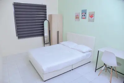 a white bedroom with a bed and a desk at The Karaoke Homes Ipoh, Oldtown in Ipoh