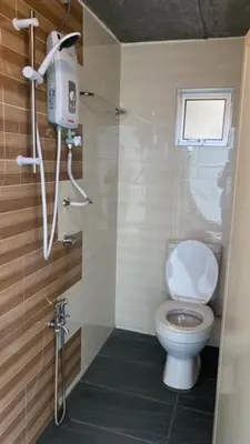 a small bathroom with a toilet and a window at Cameron Highlands Blueberry Earth House in Cameron Highlands