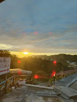a view of the sunset from a building with a sign at Cameron Highlands Blueberry Earth House in Cameron Highlands