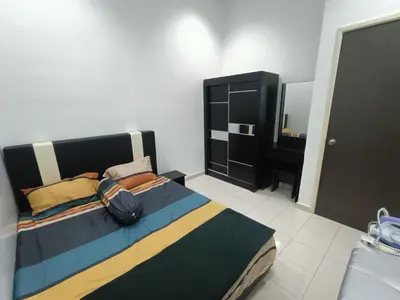 a bedroom with a large bed and a mirror at HOMESTAY BERTAM SAFAR in Kepala Batas